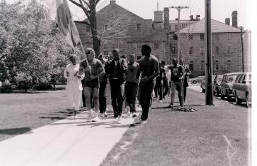 Students marching on a sidewalk.