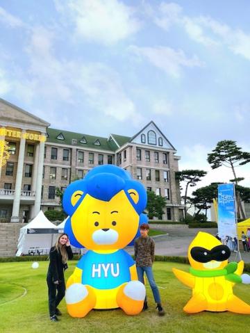 My friend and I in Hanyang Square posing with a blow-up doll of Hanyang University's mascot, Hy-Lion.
