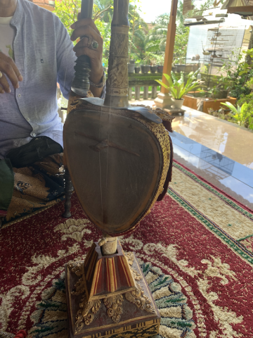 an ornate rebab (Balinese string instrument) on an ornate rug