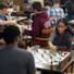 groups of students at table playing chess.
