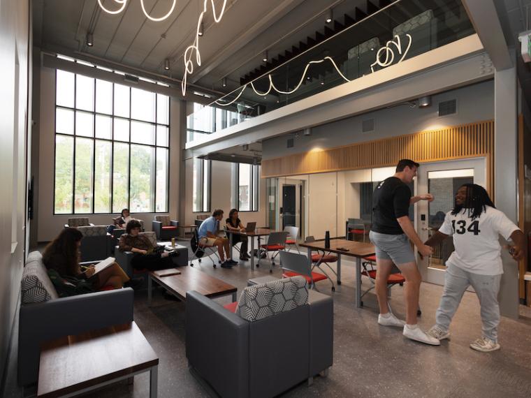 Students hanging out in a residence hall lobby.