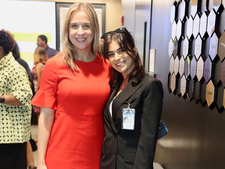 a person wearing a red dress stands next to a person wearing a black suit