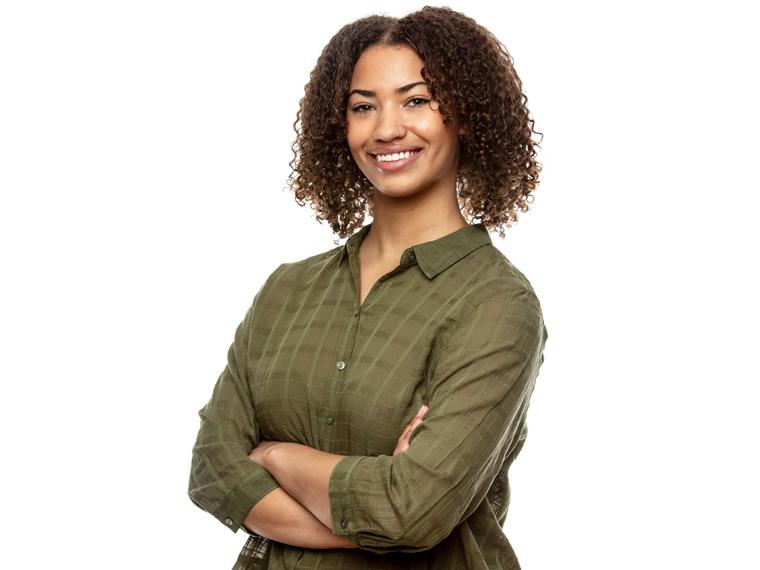 a person wearing a green shirt stands with their arms crossed