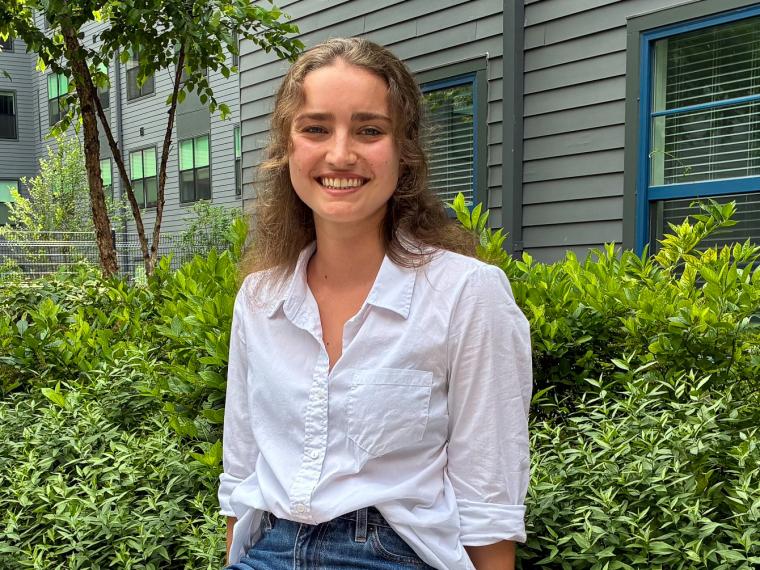 Student smiles at camera while outdoors. 