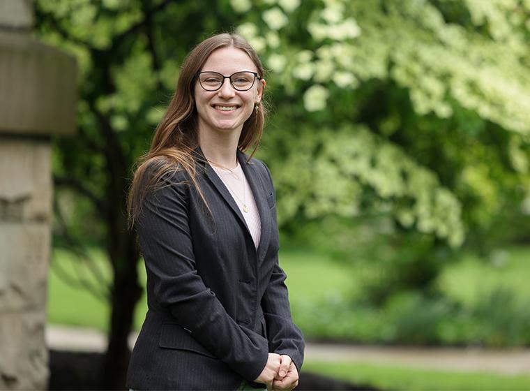 Student smiles at camera outdoors