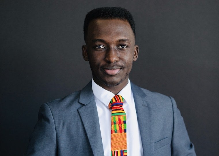 a person wearing a gray suit coat, white shirt and colorful tie