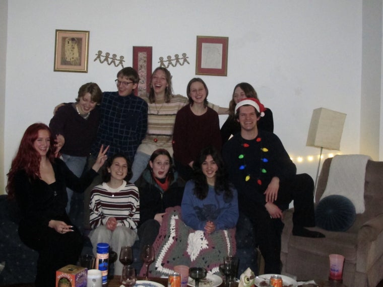 A group of friends sitting on the couch together, making silly faces