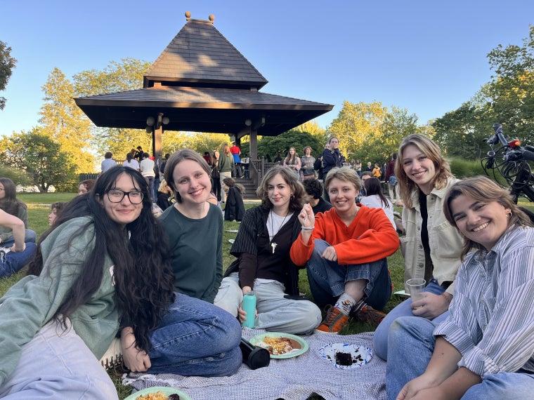 A group of students smiling before the bandstand