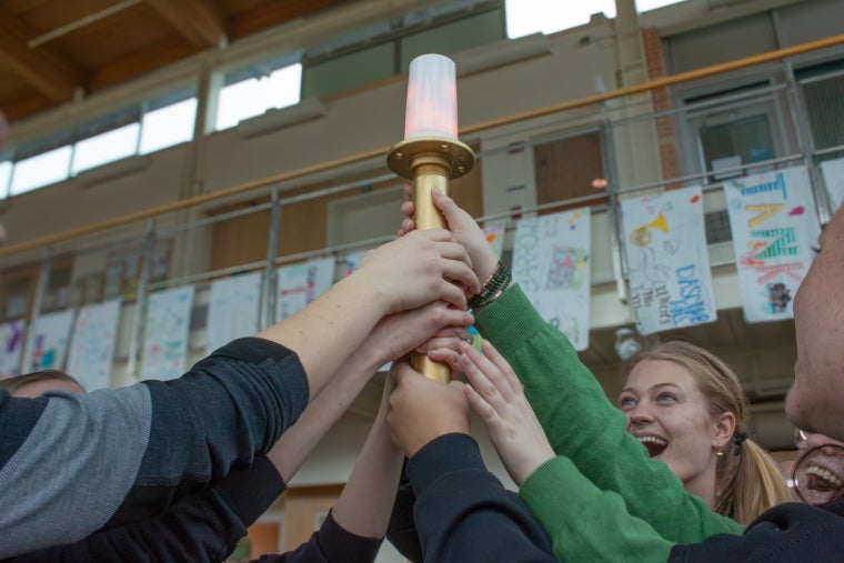 Hands holding up the Ecolympics torch