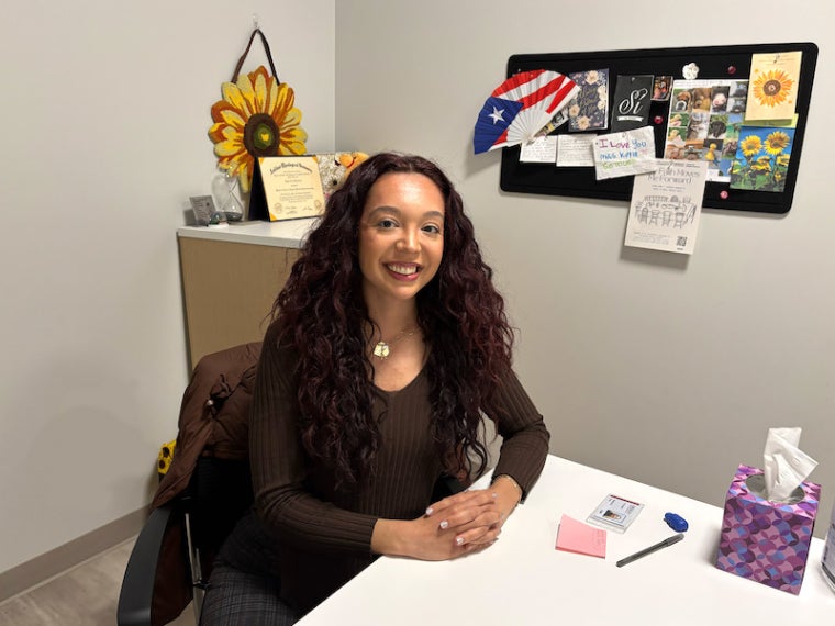 Kayla Hebebrand seated at her desk.