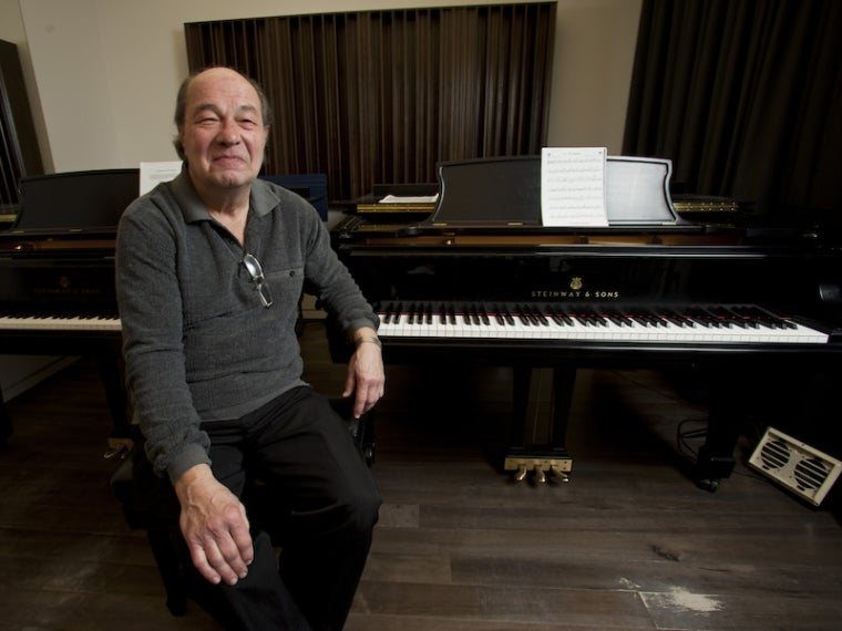 Dan Wall seated at two pianos.