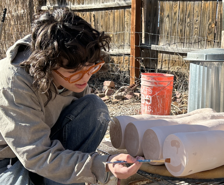 student painting pottery