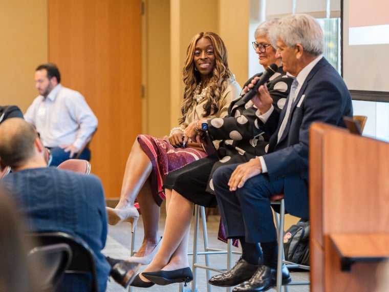 seated panelists cheerfully speaking.