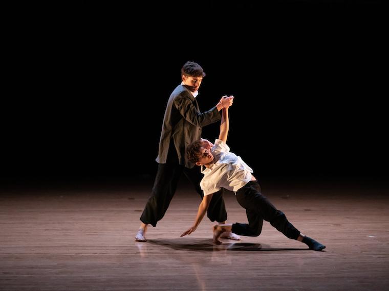 two people on stage doing a dance move; one upright, the other on the floor.