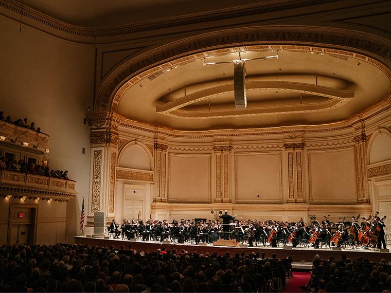 full orchestra in concert on Carnegie Hall stage