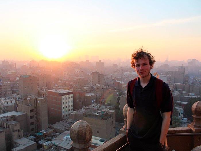 A student with a view of Cairo at sunset.