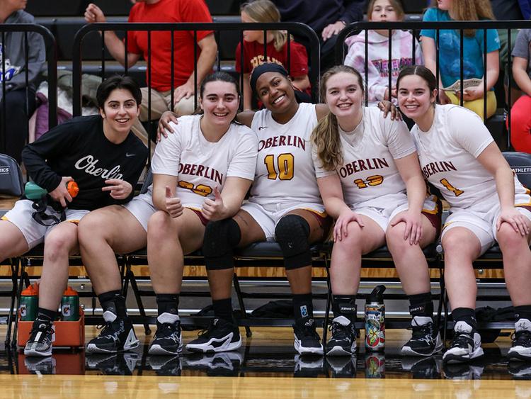 Women's Basketball team smiling from bench