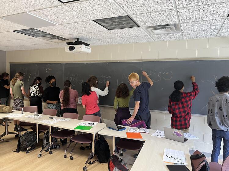 students writing on a chalkboard