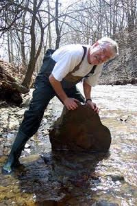 Roger F. Thoma standing in a river