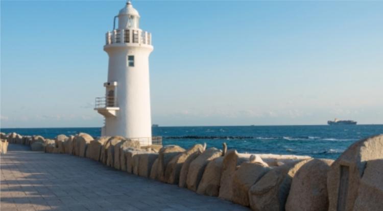 A white lighthouse and paved pier against the ocean on Japan's Atsumi peninsula