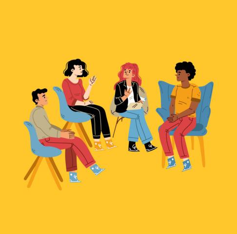 A group of people seated and talking on a yellow background