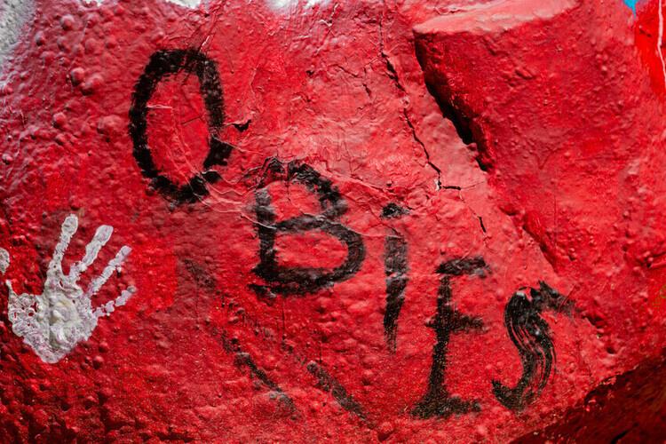 Rock at Tappan square painted red with white handprints and the word "Obies"