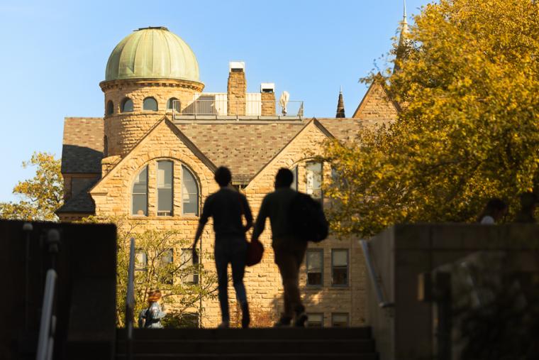 Backlit students walking on campus.