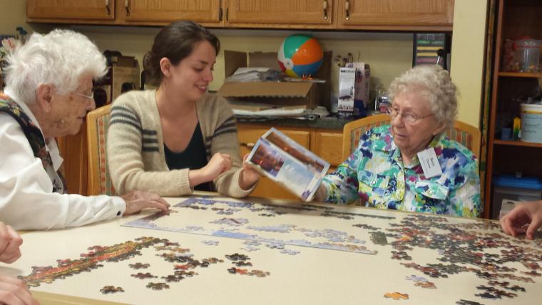 Emilia Varrone ’16 building a puzzle with Kendal residents