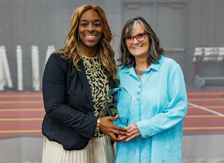 Portrait of smiling staff and president with award.