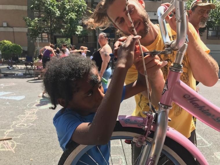 Josh helps a little neighbor fix his handlebars in Williamsburg.