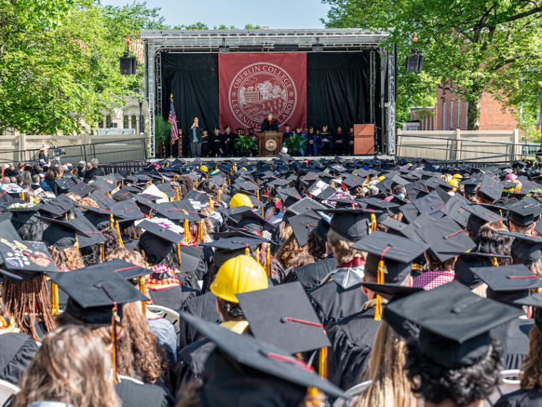 many students in mortarboards facing the commencement stage.