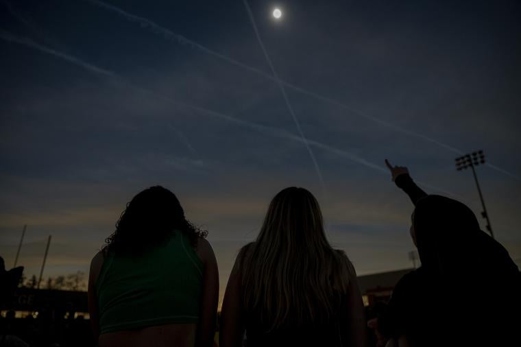 People looking up and pointing at the totality of the solar eclipse.