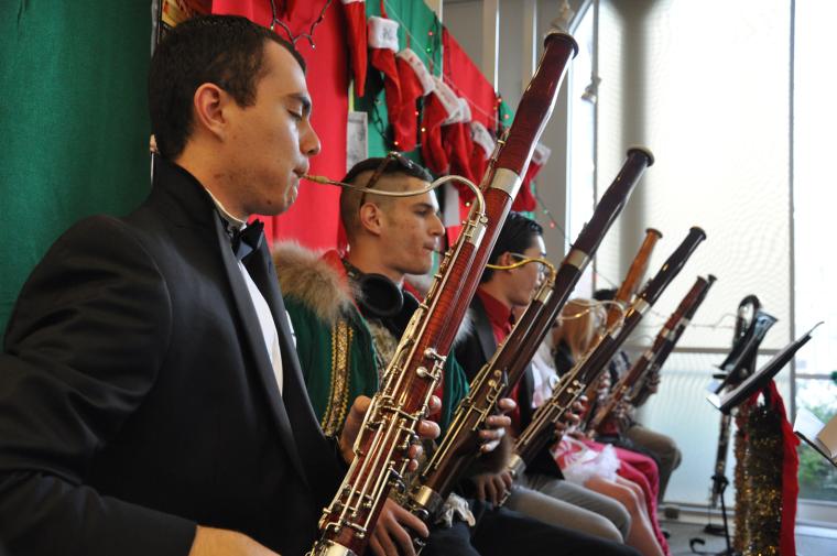 Bassoonists seated under a row of Christmas stockings