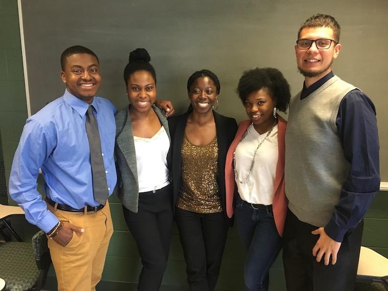 Andre Cardine, Thoebeka Mnisi, Afia Ofori-Mensa, Niya Smith, and Brian Cabral stand next to each other with their arms around each other in the King building