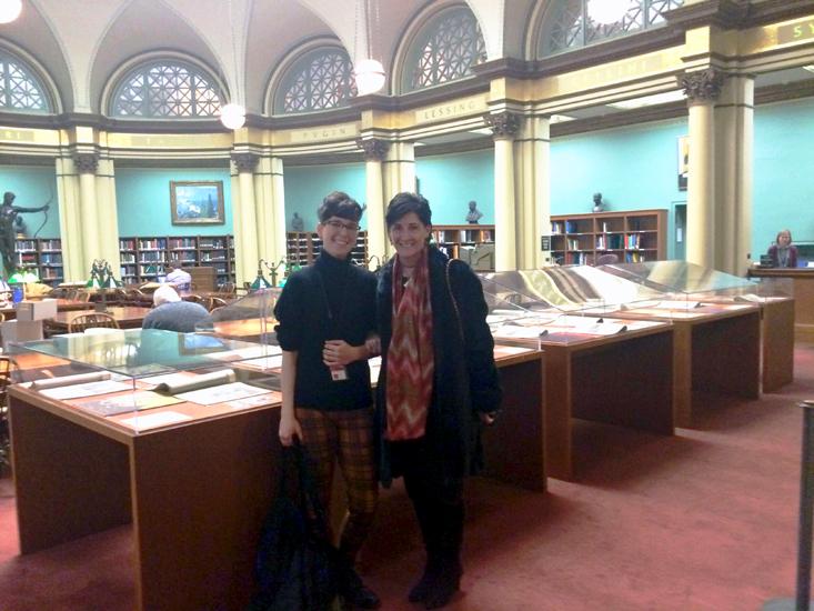 Two people in a library with documents displayed in glass cases