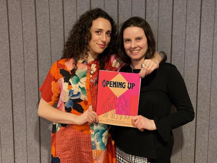 Fleischacker and Minion hold up a copy of their zine, Opening Up.