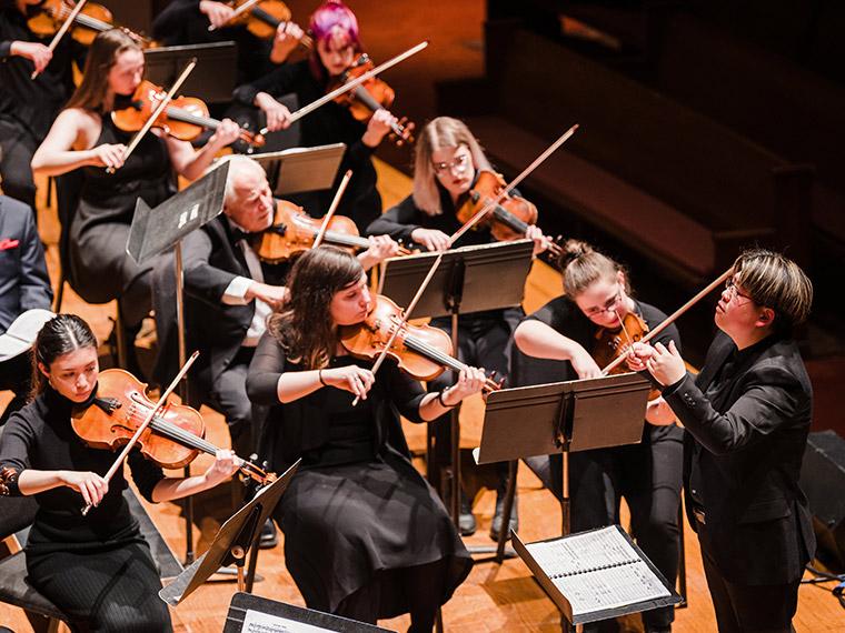 Violin section and conductor