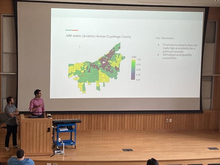 Student presents research on large screen.