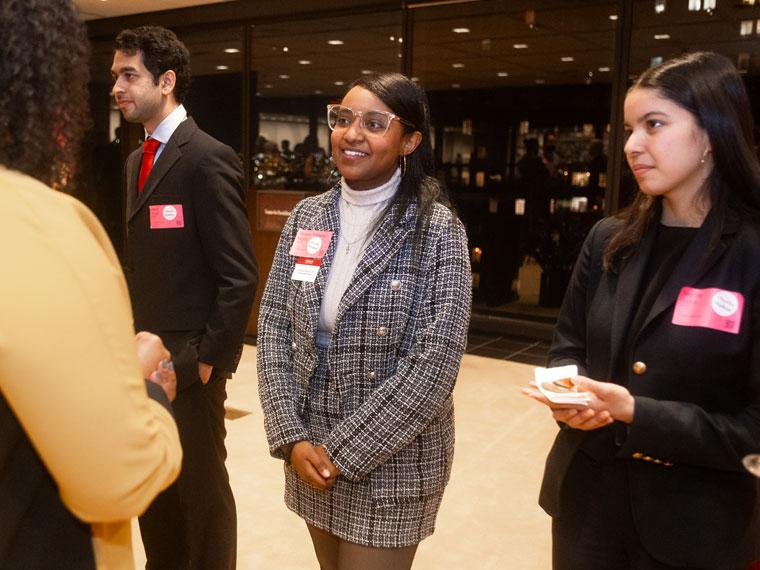 three students talking at a business networking event