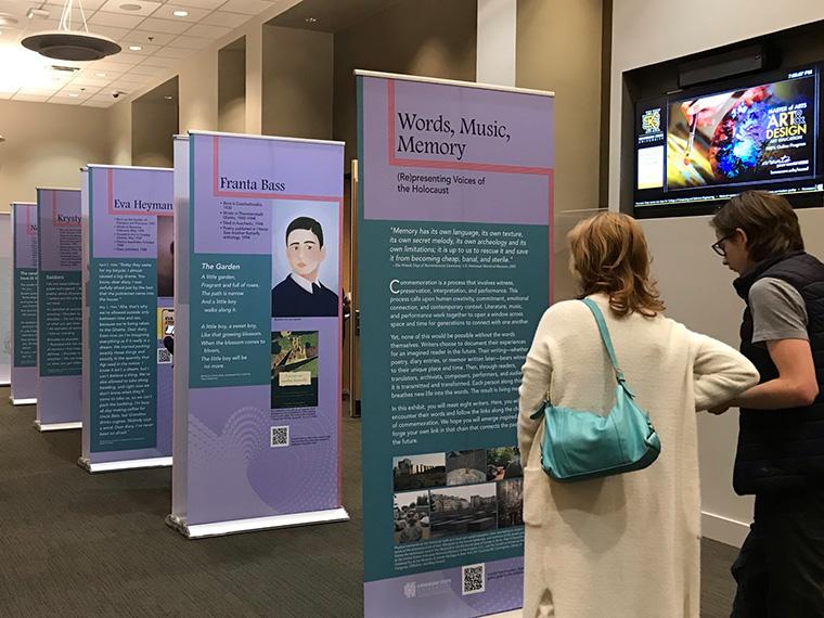 two people look at the words, music, memory exhibition