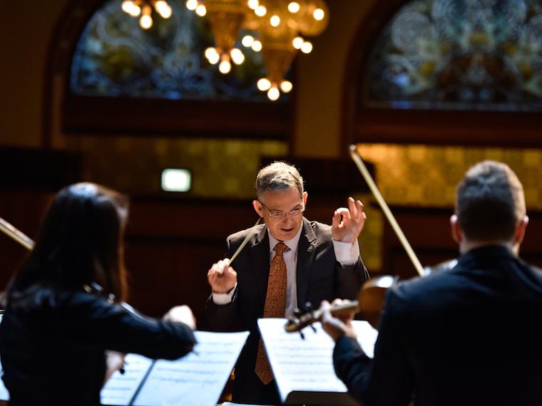 Conductor leading musicians in performance.