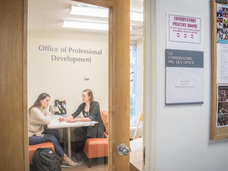 career advisor working with a student in an office.
