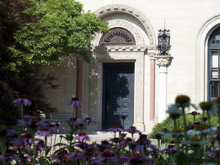 Cox Administration Building entry door framed by tree and flowers