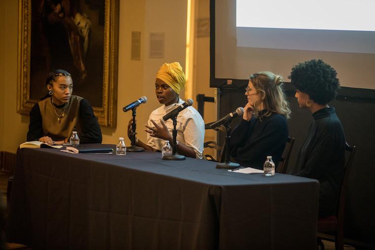 one of three panelists at table speaking