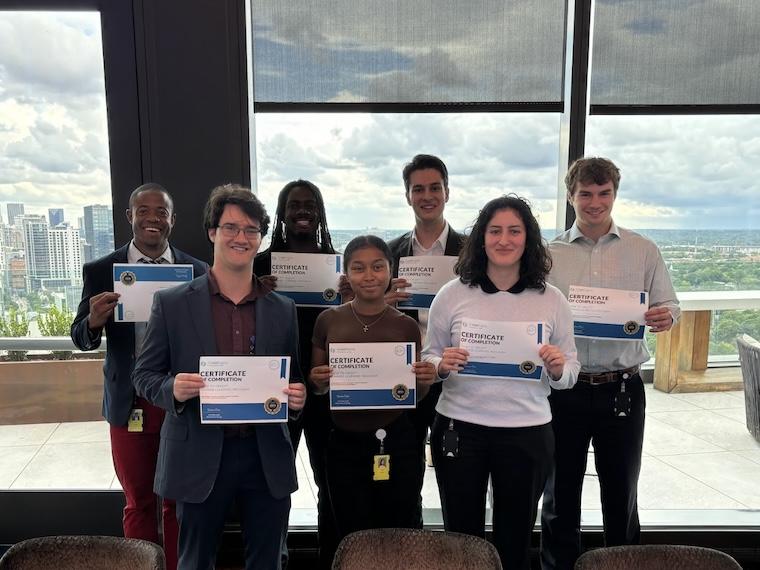 Group poses in front of window.