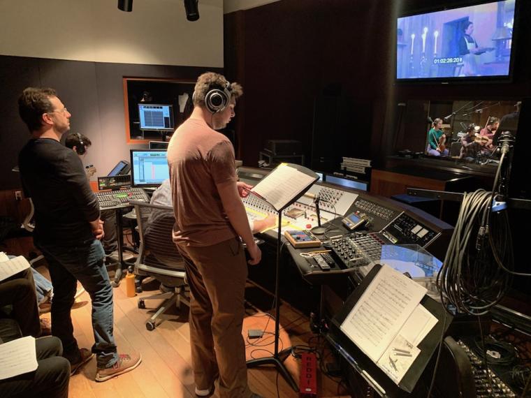 an Oberlin student works in the recording studio with audio production staff and a guest composer.