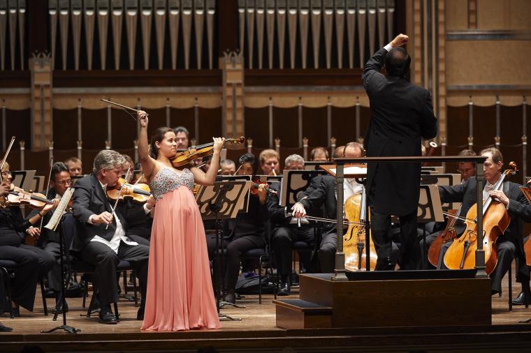 A violin soloist performs with an orchestra