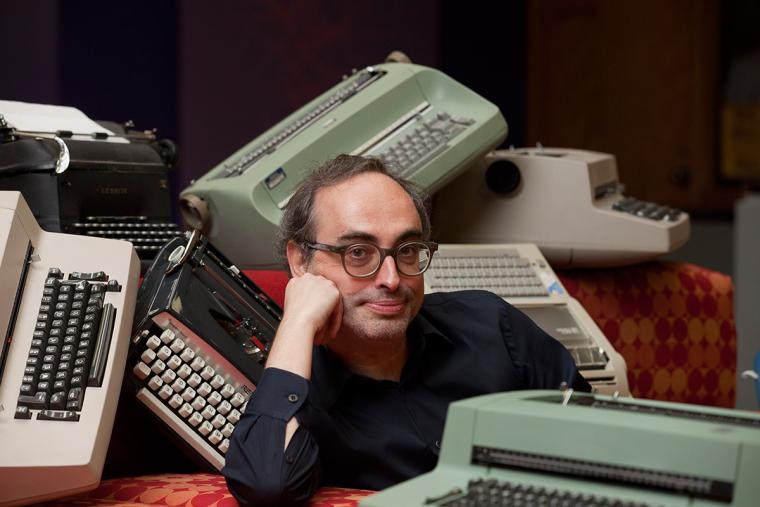 Shteyngart amidst mechanical and electric typewriters that have been strewn about carelessly..