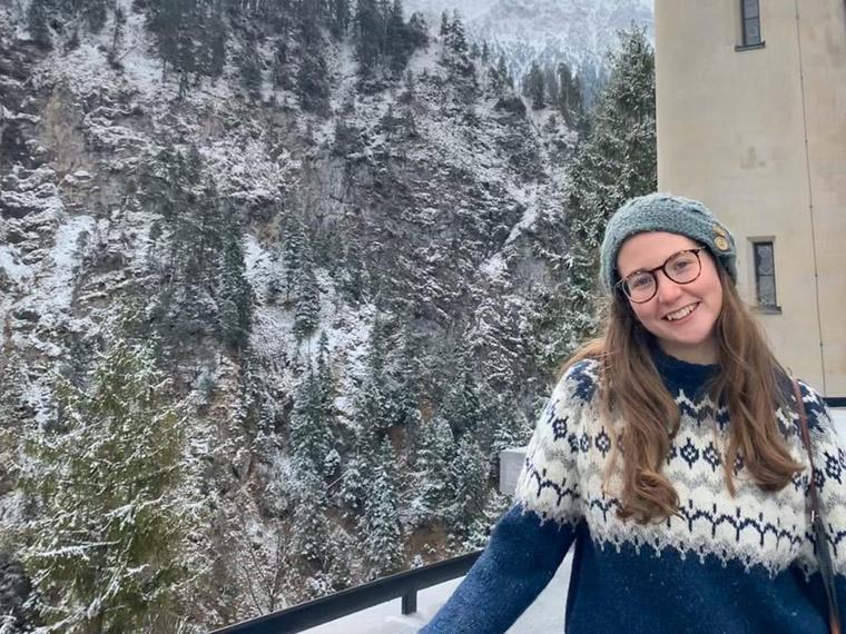 Hannah Scholl in front of snow covered pine trees.
