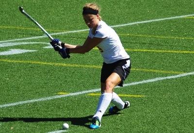 A field hockey athlete goes after the ball.